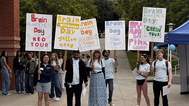 Students holding colorful signs at UCR brain day